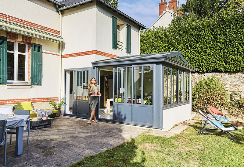 Extension sous forme de véranda ouvrant sur la terrasse devant la maison