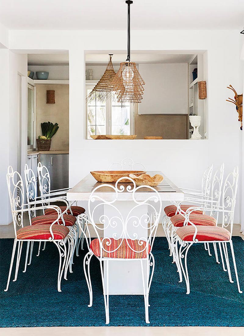 Une salle à manger avec des chaises en fer forgé chinées