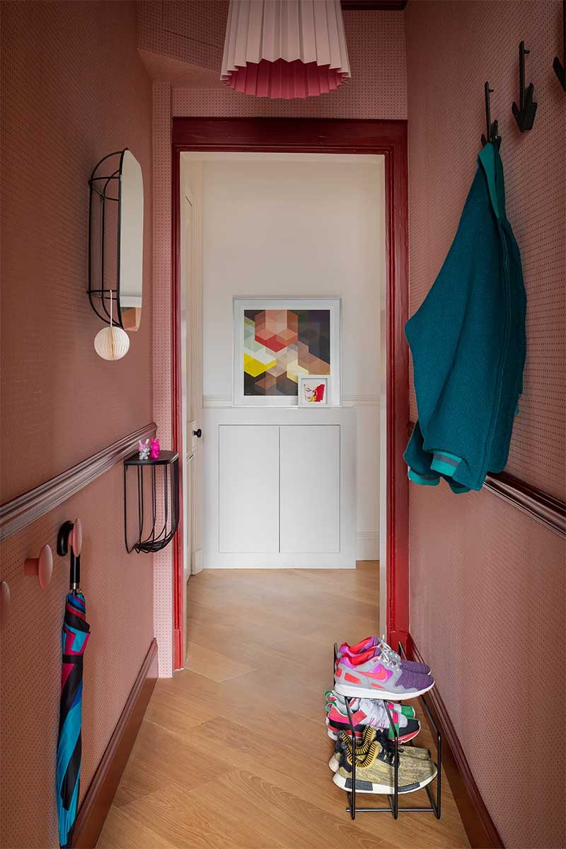 Une entrée moderne en rose et rouge avec des accessoires design