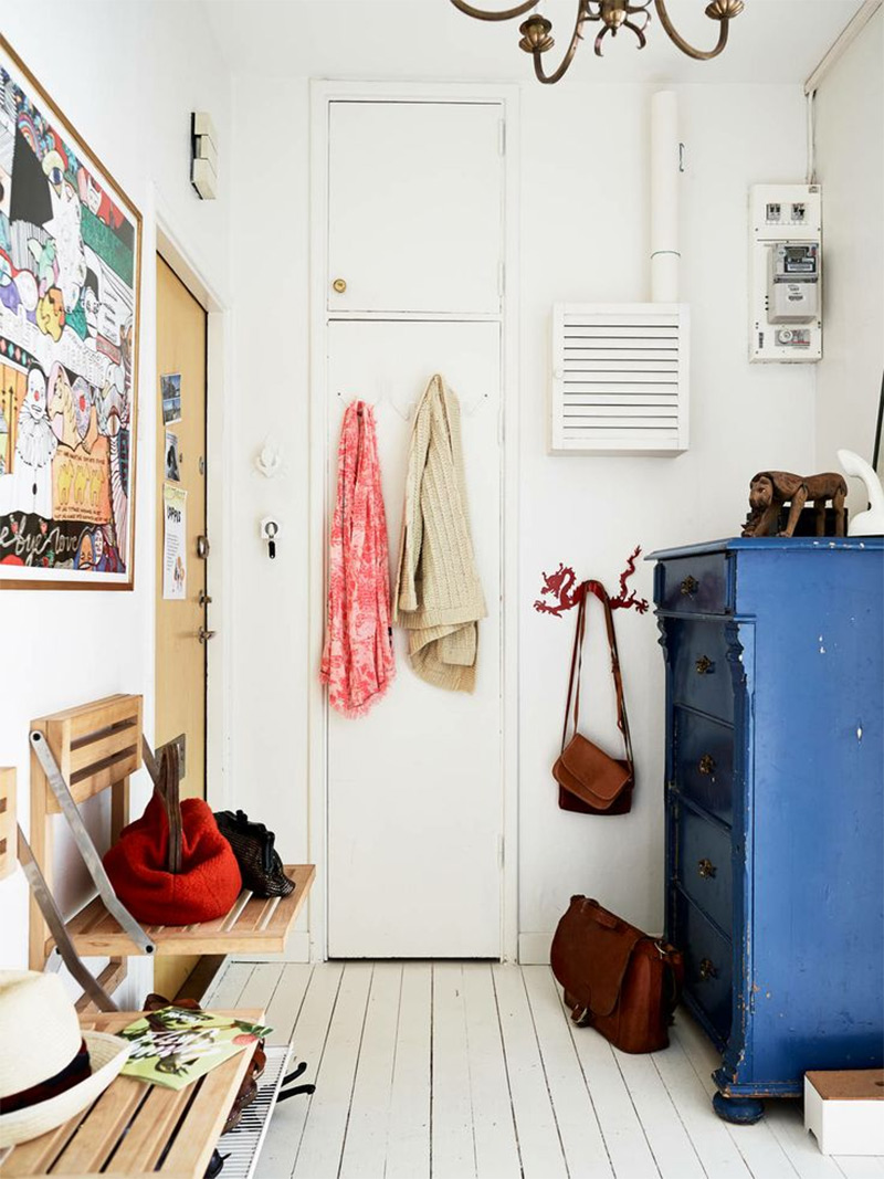 Petite entrée d'appartement au style scandinave, avec sa petite commode bleue et son lustre vintage