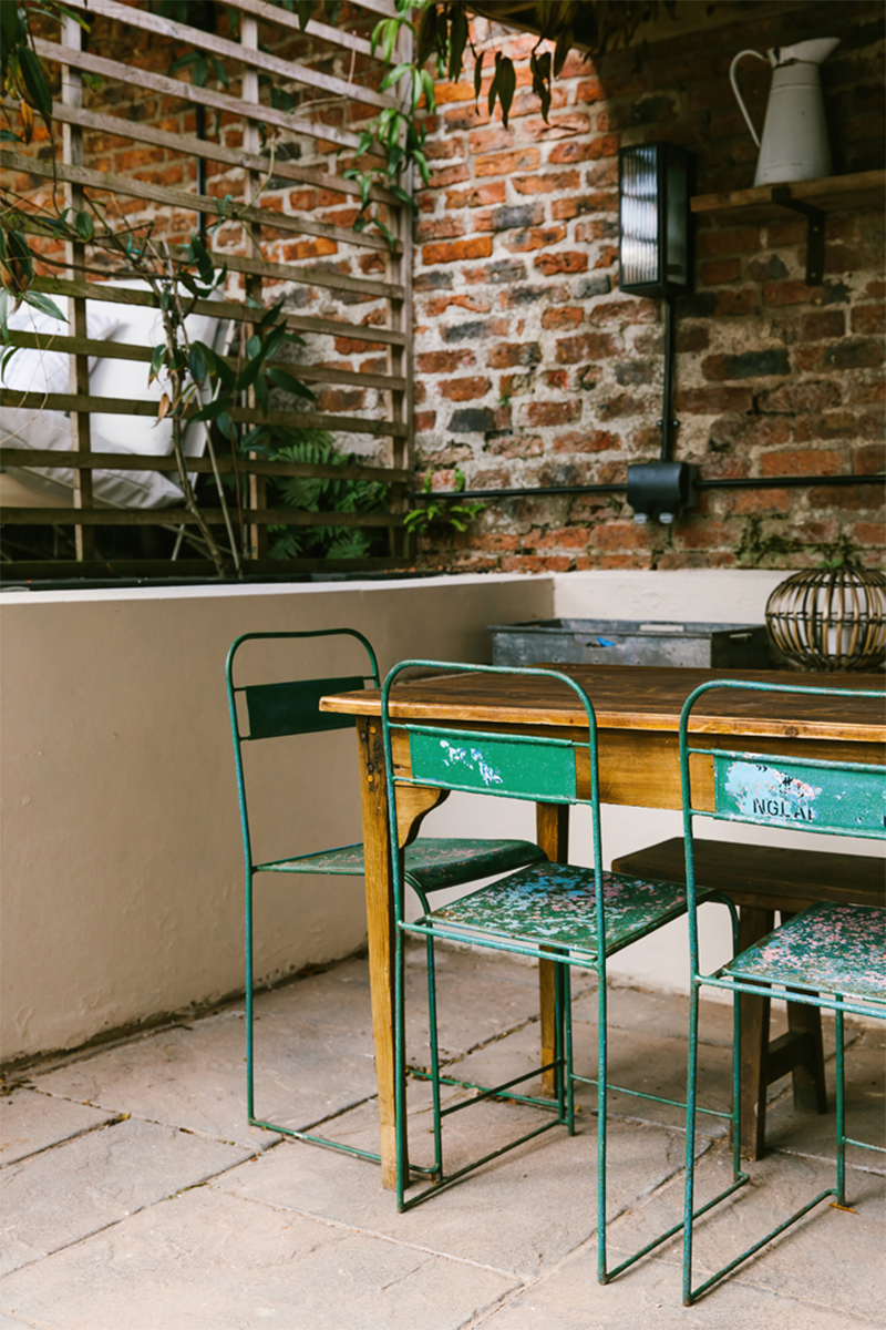 Chaises de jardin vintage en métal patiné et table en bois pour cette terrasses éxtérieure
