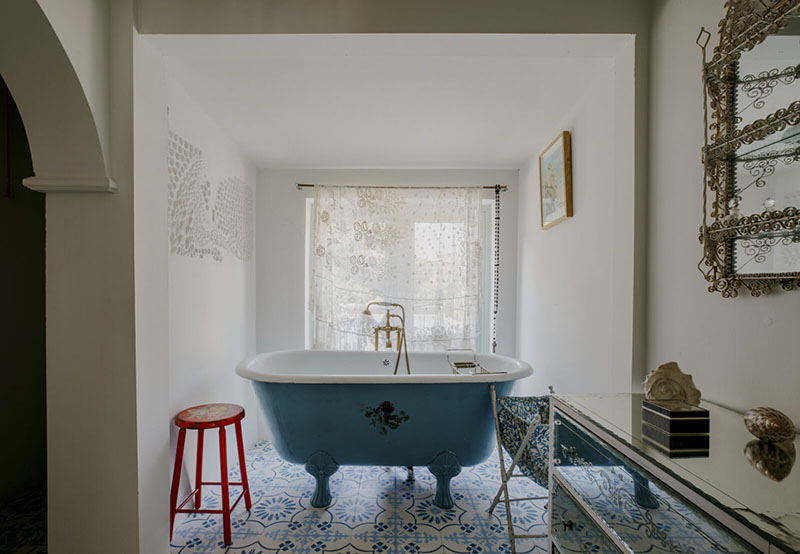 Une salle de bains au look antique avec sa baignoire à pied de lion repeinte en bleu