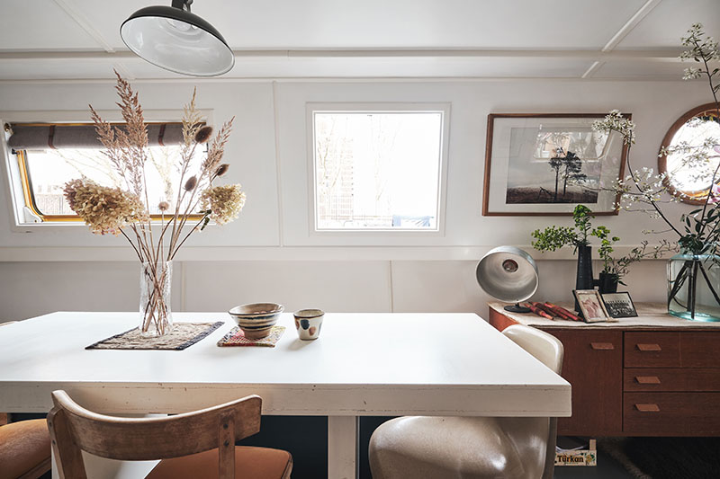 Une table blanche design et des chaises chinées