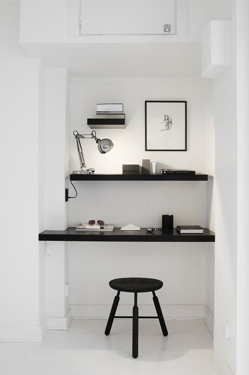 Un bureau installé dans un recoin d'appartement, décoré en noir et blanc pour un style scandinave minimaliste