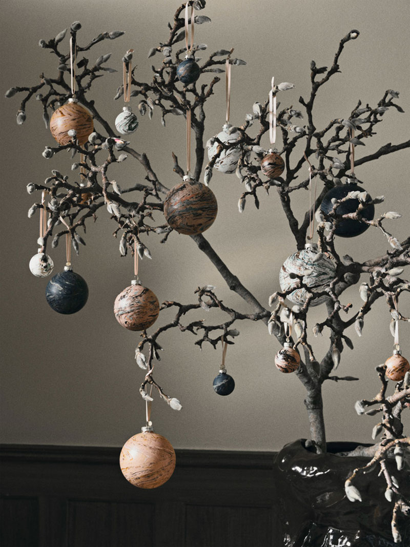 Catalogue de Noël Ferm Living 2023 - Branche d'arbre décorée avec des boules de Noël