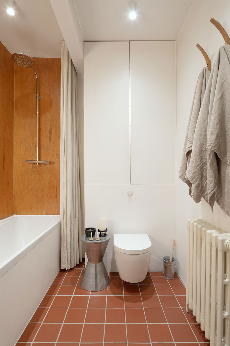 Une salle de bain avec un sol en faïence rouge terracotta