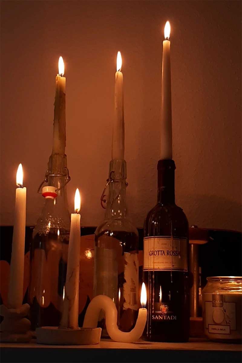 Des bougies dans des bouteilles de vins pour une ambiance de Noël vintage