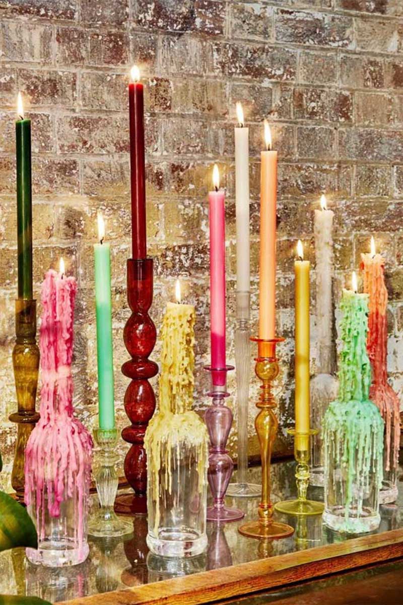 Des bougies plantées dans des bouteilles avec d'autres chandeliers
