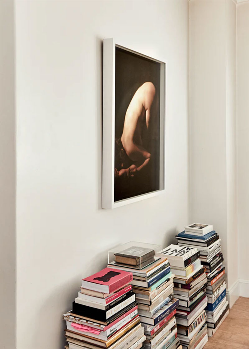 Photo d'art et piles de livres d'art posés sur le parquet