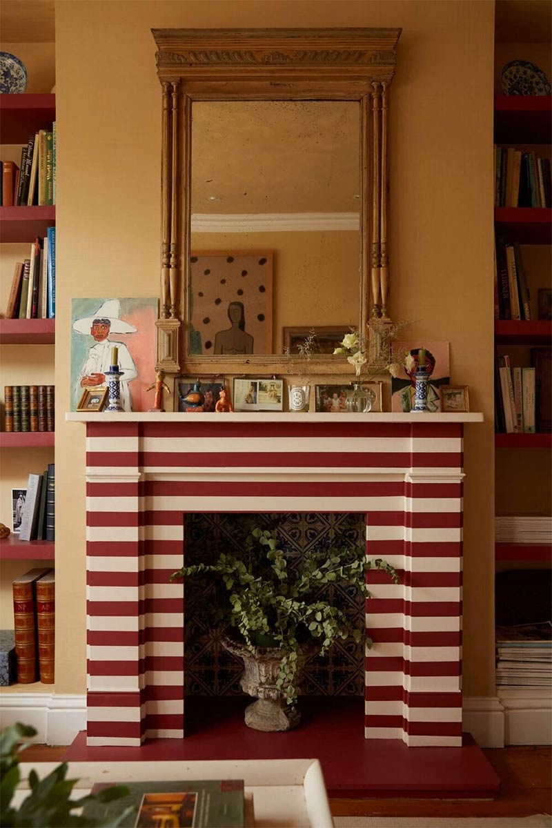 La cheminée décorée de rayures horizontales rouge et blanc dans l'intérieur londonien d'Alice Palmer