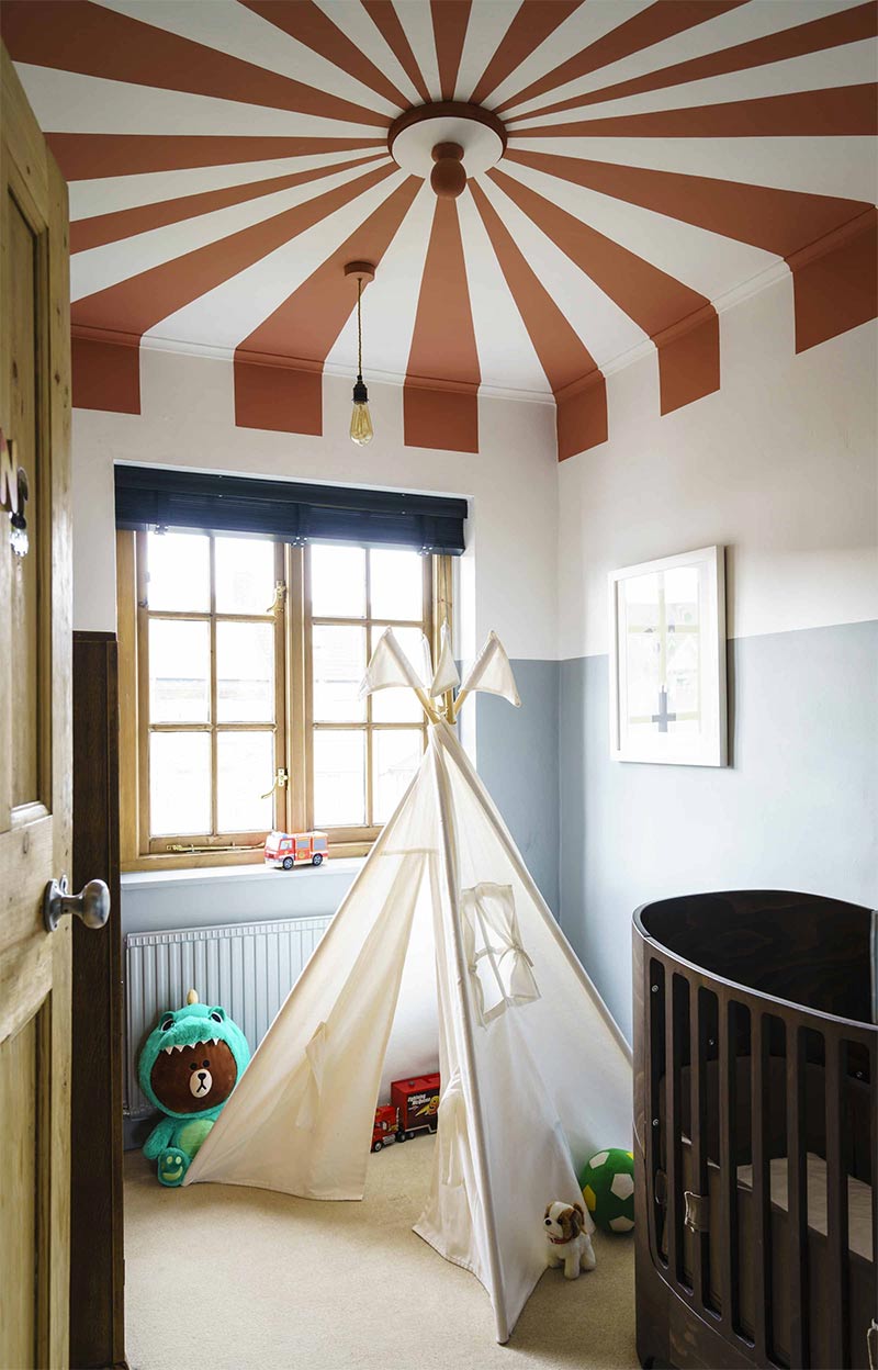 Une chambre d'enfant avec un plafond peint, façon chapiteau de cirque