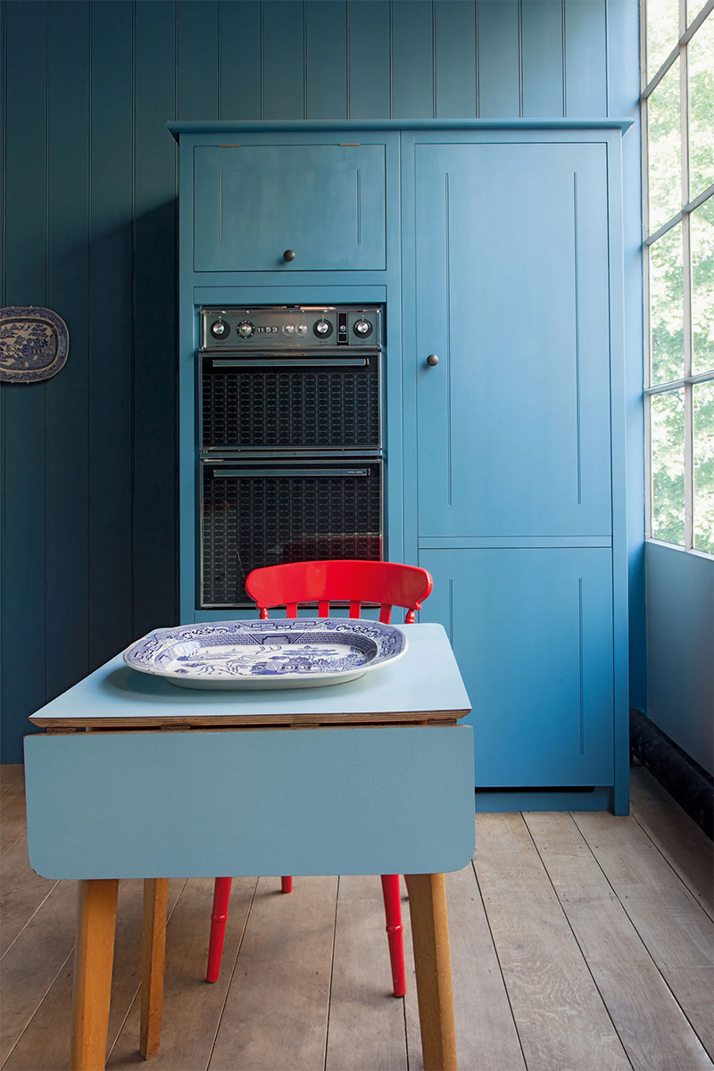 Une chaise rouge vif pour une cuisine bleue