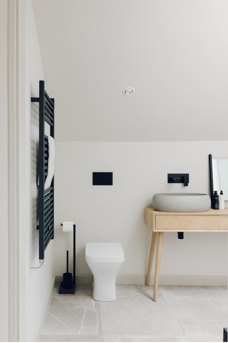 Salle de bains de style nordique avec meuble en bois et murs blancs