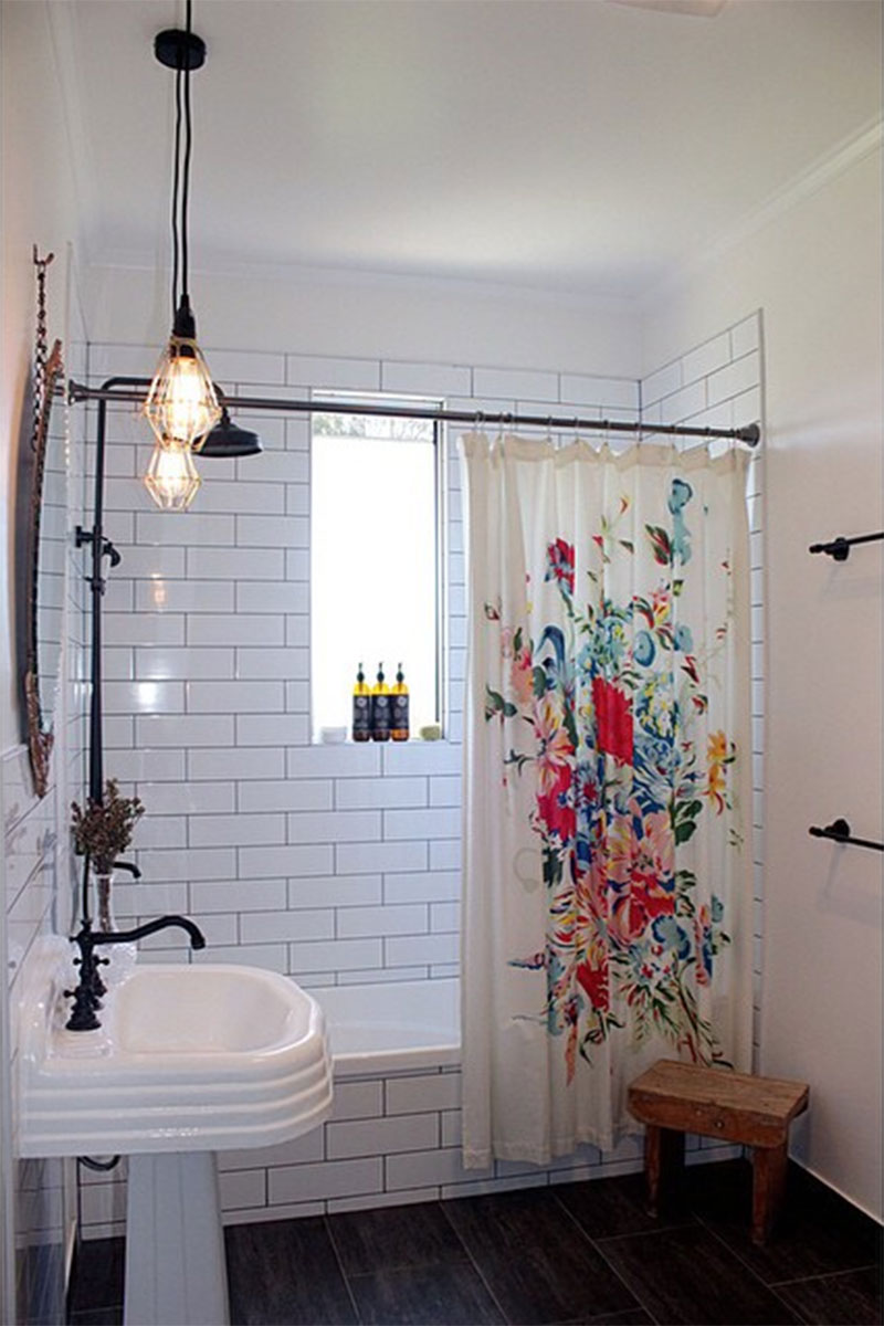 Un rideau de douche à fleurs dans une salle de bains au look antique en blanc et noir