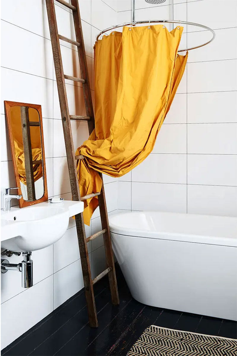 Une installation de rideau de douche moutarde au-dessus de la baignoire