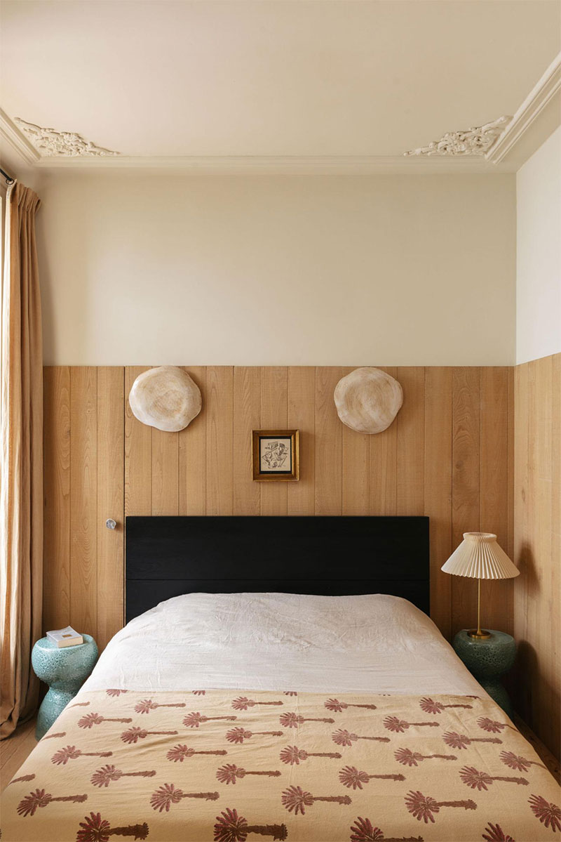 Une chambre présentant un lambris de bois d'origine locale