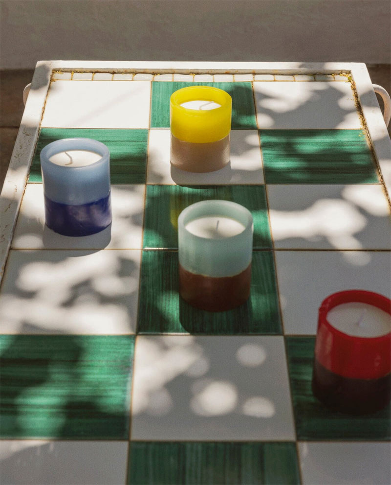 La collection de bougies parfumée sur une table à damier vert et blanc