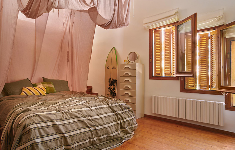 Une chambre assez minimaliste avec un ciel de lit