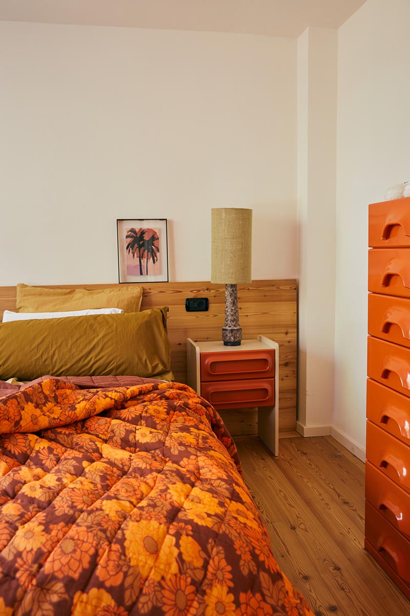 Une chambre à la décoration complètement rétro avec des imprimés à fleurs orange et du mobilier de style Spage Age
