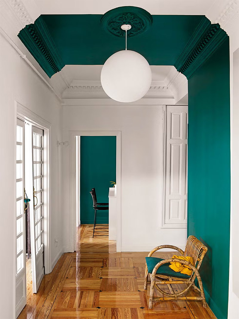Un couloir marqué par un aplat de couleur vert émeraude