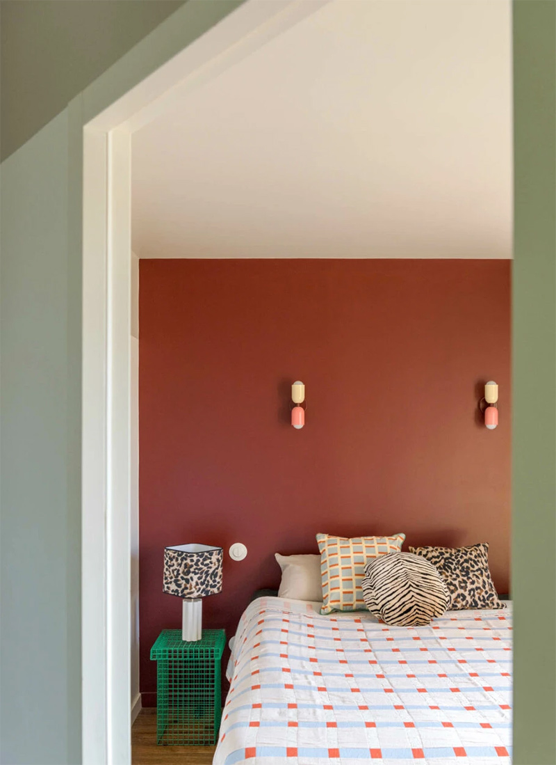 Une chambre avec un mur rouge bordeaux