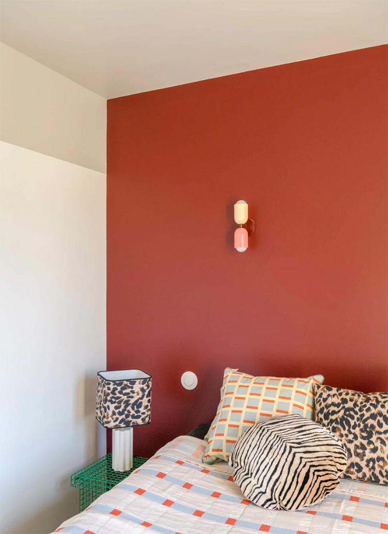 Une chambre avec un mur rouge bordeaux
