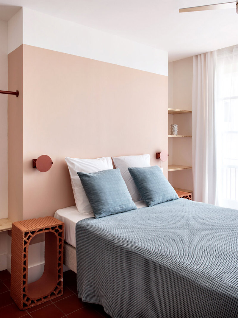 Pan de mur derrière la tête de lit comme une colonne pour cette chambre d'hôtel