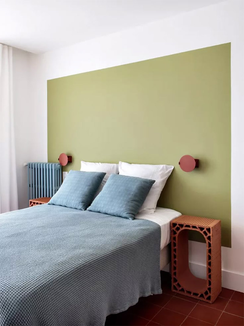Panneau vert peint derrière le lit pour cette chambre d'hôtel