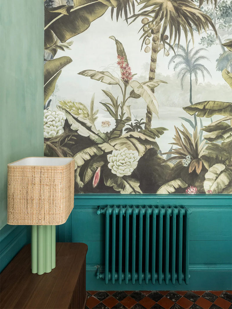 Papier peint panoramique de style tropical avec des boiseries bleues et murs peints en vert Papier peint panoramique de style tropical avec des boiseries bleues et murs peints en vert