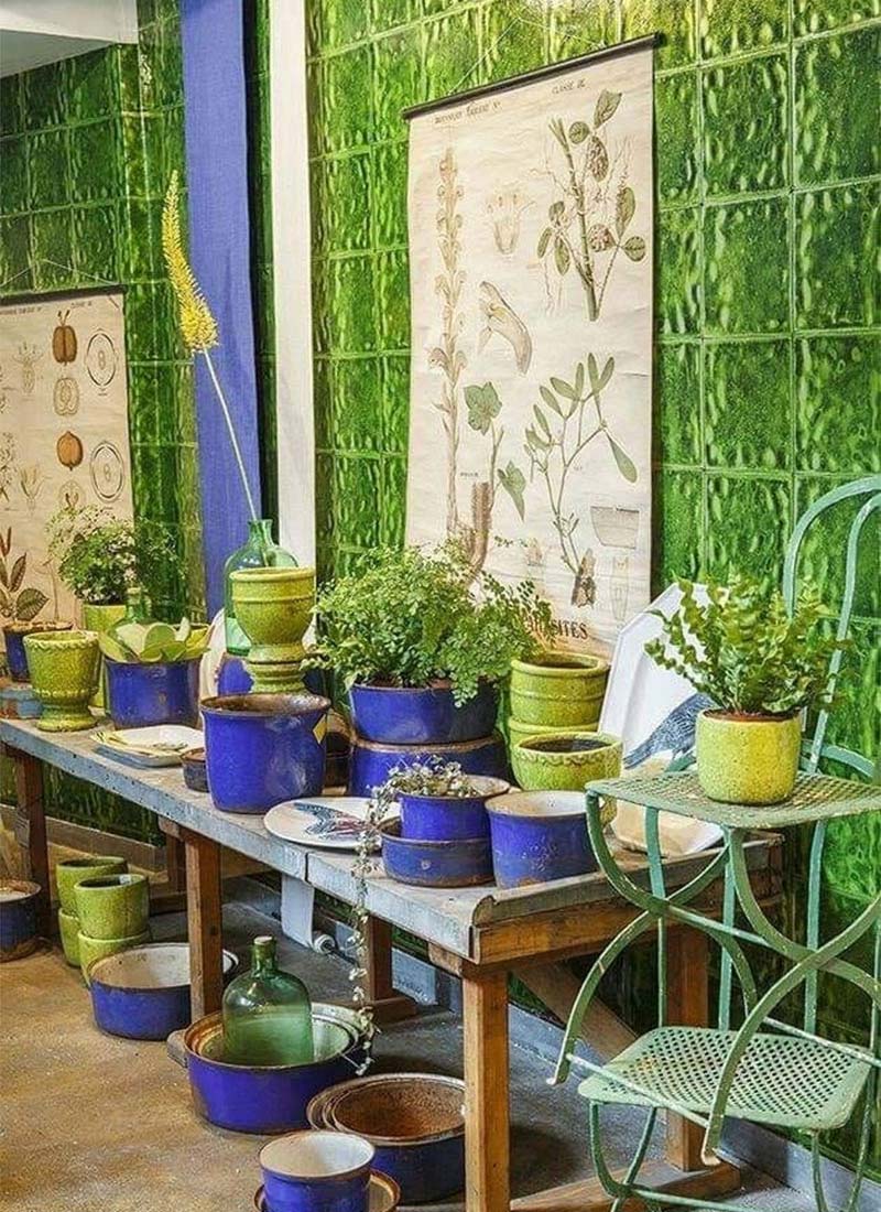 Mise en scène d'un mur en céramique vert et de pots de fleurs bleu indigo et vert Mise en scène d'un mur en céramique vert et de pots de fleurs bleu indigo et vert