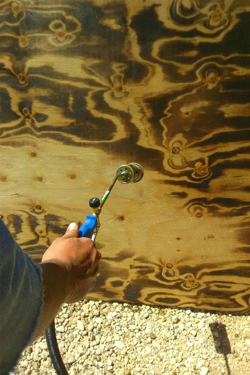 Planche de pin brûlée au chalumeau pour faire ressortir les veines du bois Planche de pin brûlée au chalumeau pour faire ressortir les veines du bois