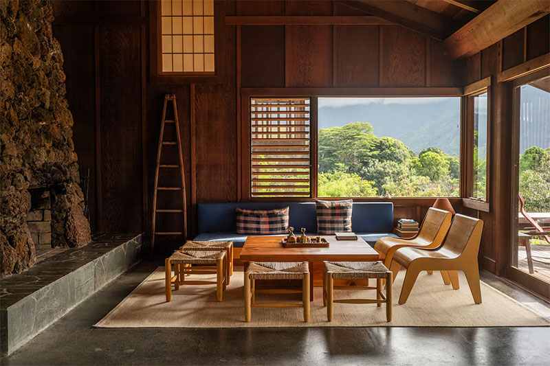 Le salon avec sa cheminée en pierre et la vue omniprésente sur le paysage extérieur de la baie de Hanalei Le salon avec sa cheminée en pierre et la vue omniprésente sur le paysage extérieur de la baie de Hanalei