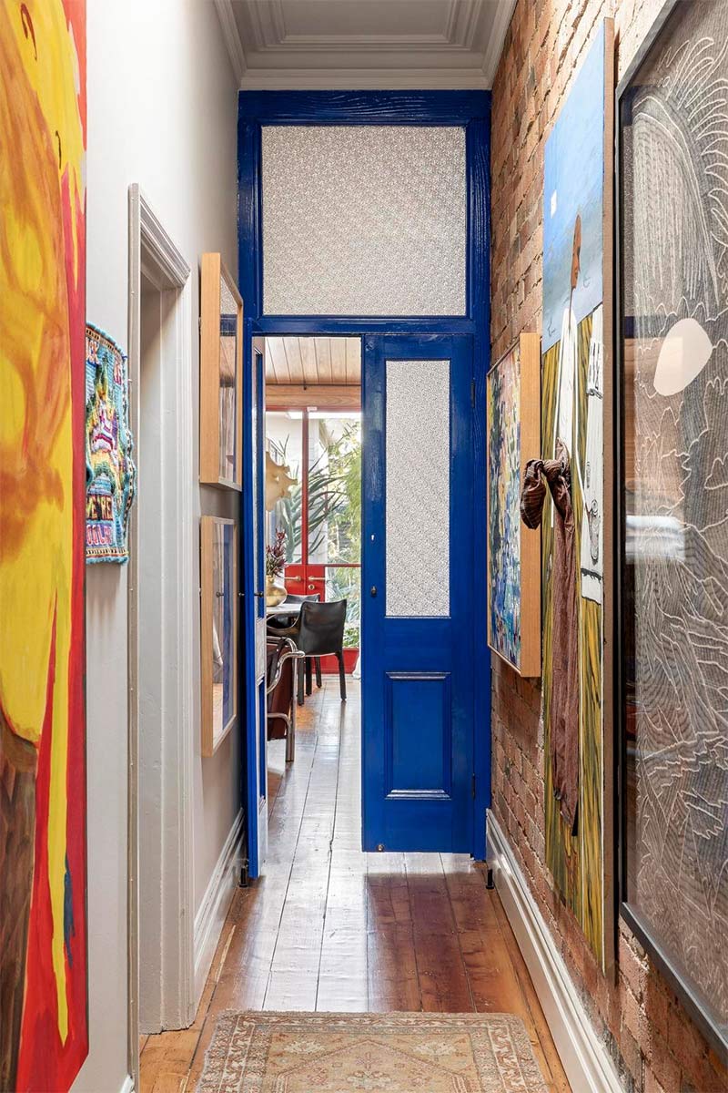 Couloir distribuant les chambres et le salon avec une porte laquée bleu électrique Couloir distribuant les chambres et le salon avec une porte laquée bleu électrique