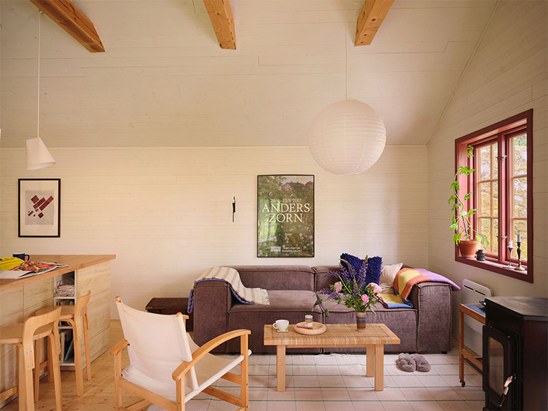 Le coin salon avec son canapé gris et son fauteuil en toile blanche Le coin salon avec son canapé gris et son fauteuil en toile blanche