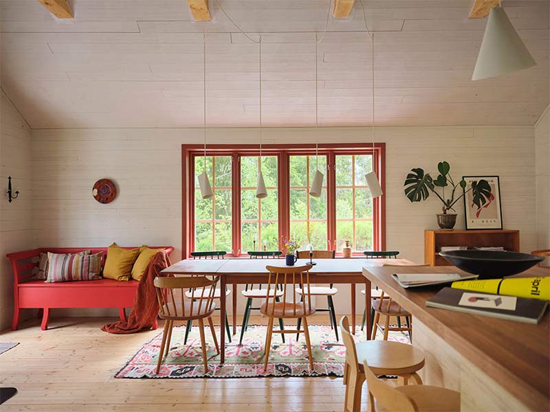 La table de salle à manger rectangulaire avec ces chaises en bois Hay face à une grande fenêtre donnant sur le jardin La table de salle à manger rectangulaire avec ces chaises en bois Hay face à une grande fenêtre donnant sur le jardin