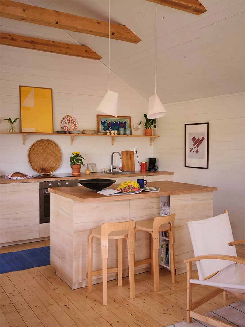 Vue sur la cuisine en bois clair avec son îlot central Vue sur la cuisine en bois clair avec son îlot central