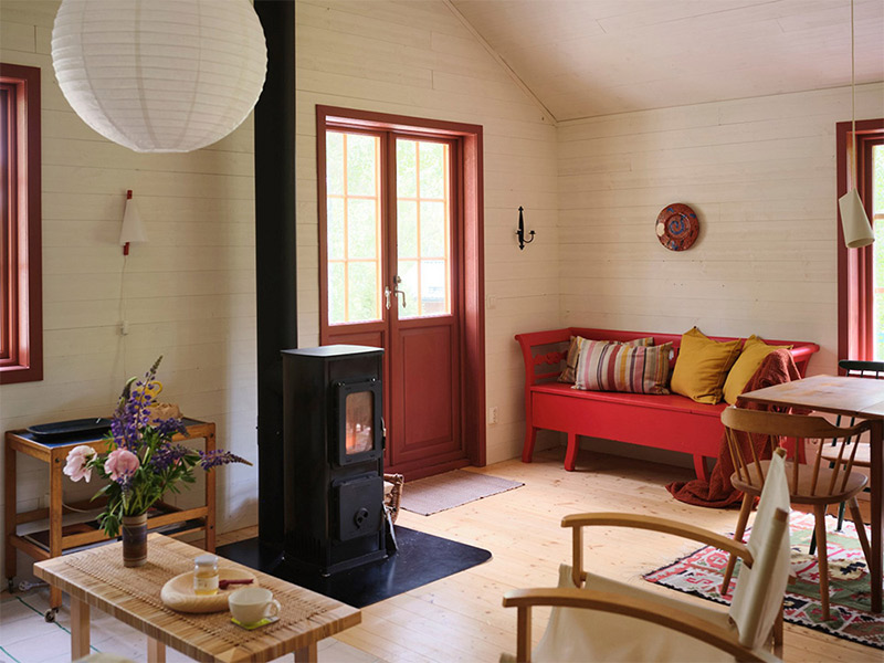 La porte-fenêtre donnant sur le jardin, peinte en rouge comme le banc scandinave La porte-fenêtre donnant sur le jardin, peinte en rouge comme le banc scandinave