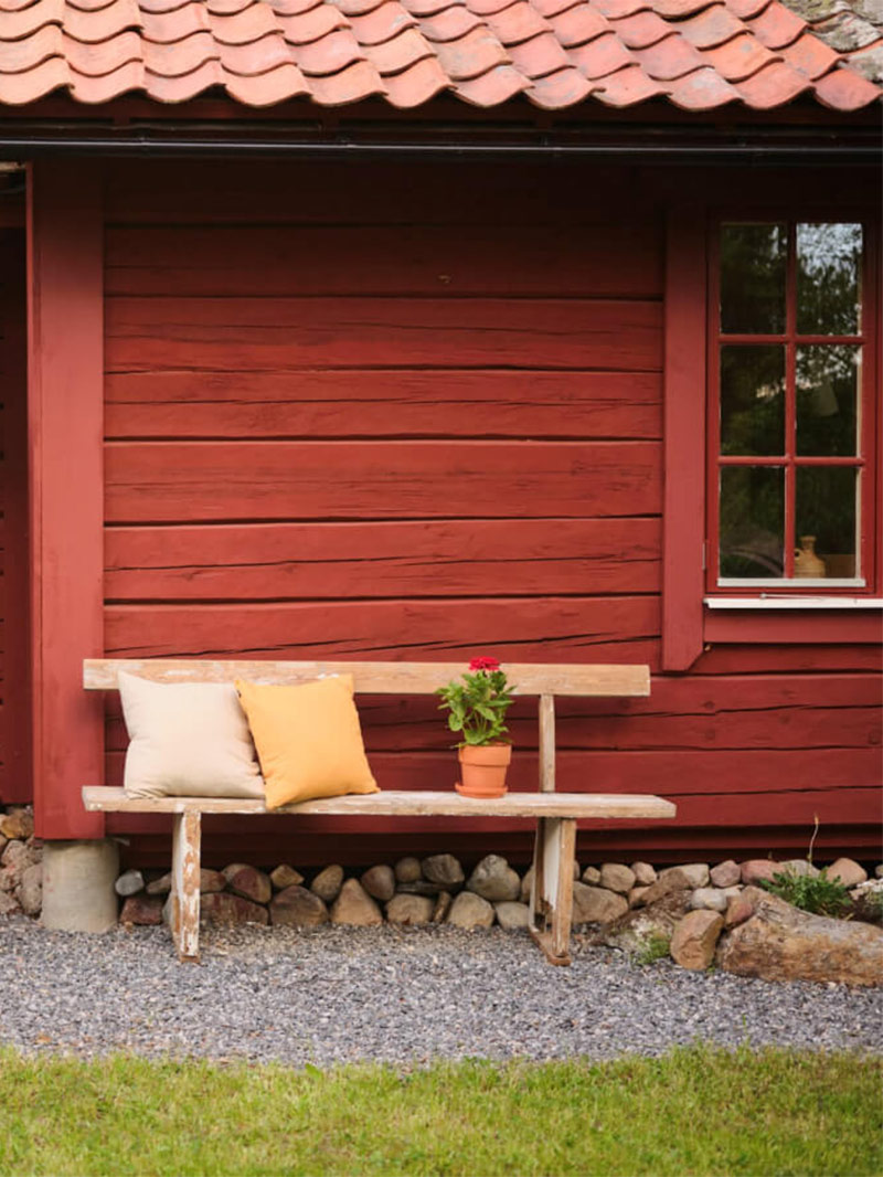 L'entrée principale de la maison en gravillon avec un banc en bois L'entrée principale de la maison en gravillon avec un banc en bois