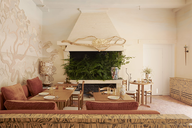 La salle à manger, présentant des décorations murales réalisées par un artiste, inspirées de la forêt