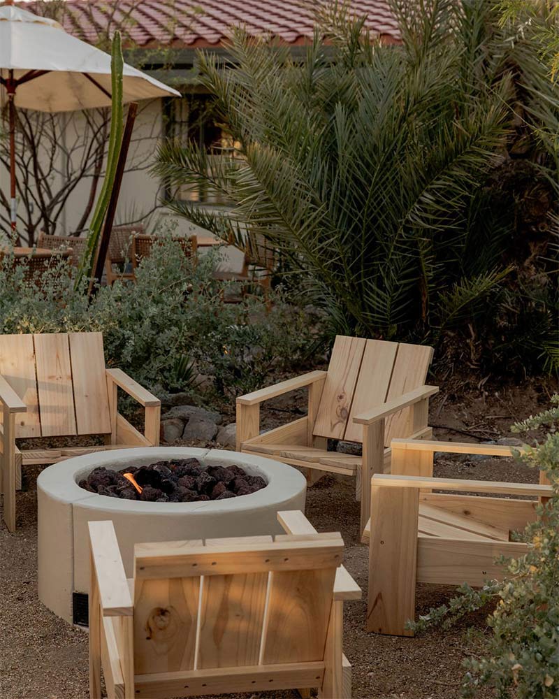 Hôtel Wren à Twentynine Palms : Un coin extérieur autour d'un braséro avec des fauteuils de style Adirondack