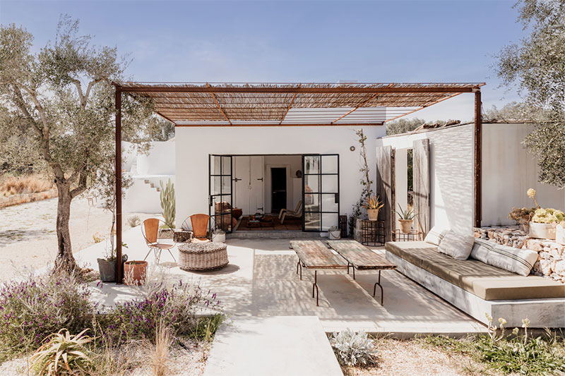 Une terrasse avec une tonnelle en canisse accueille un salon extérieur