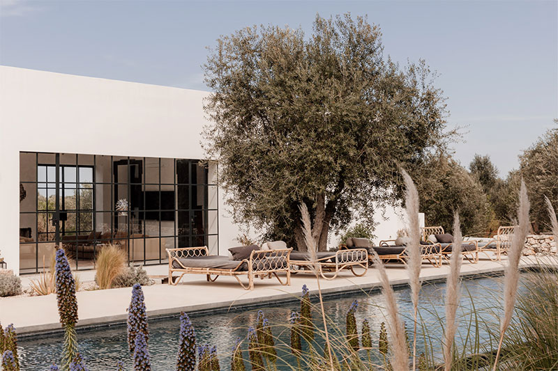 La piscine devant la maison et ses bains de soleil en rotin
