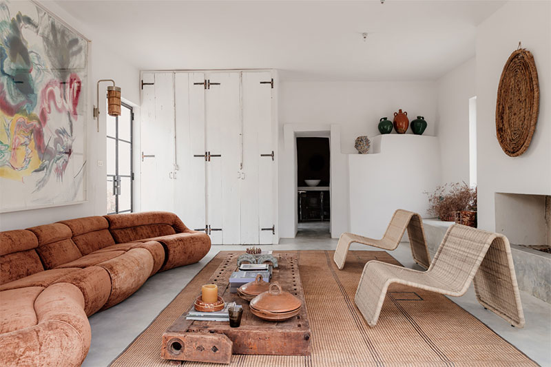 Un salon ouvert avec un canapé vintage Carrera, signé De Pas, D'Urbino et Lomazzi pour BBB Italia, et les œuvres de Jakub Milčák agrémentent le salon. 