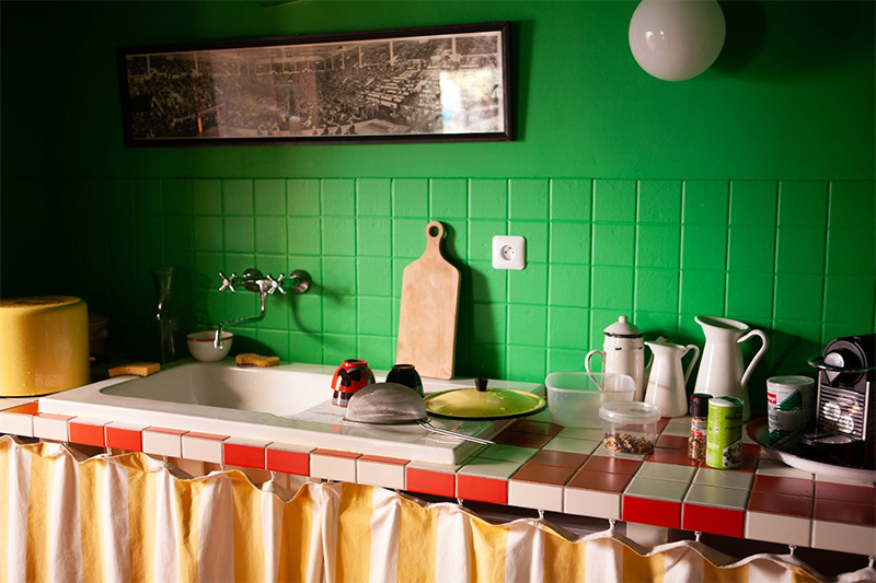 Une cuisine en mode "color block" avec un mur et crédence peints dans un vert pop