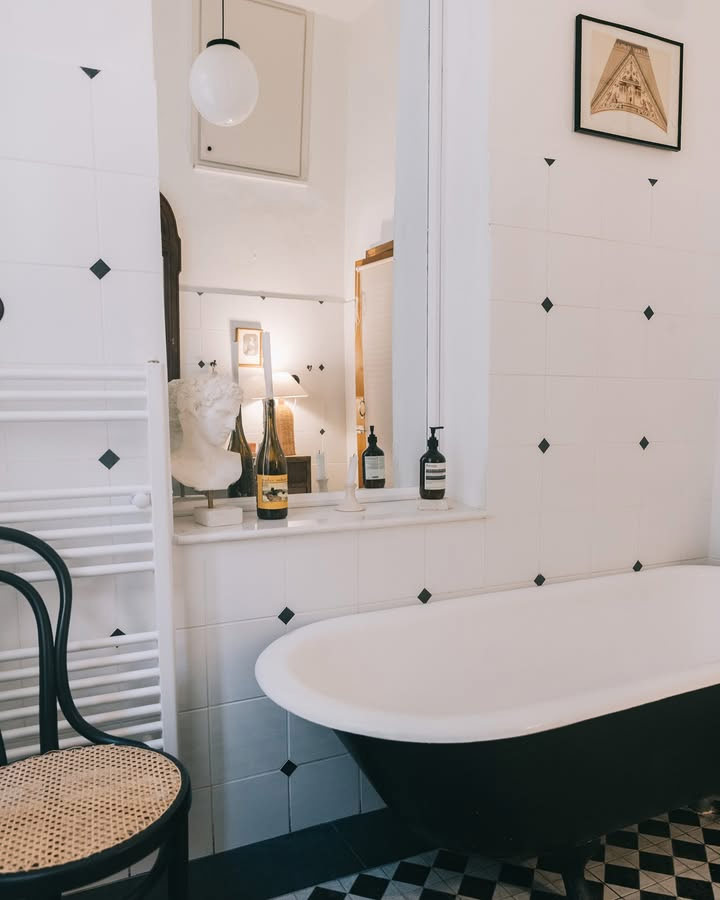 La alle de bain en noir et blanc avec sa baignoire îlot