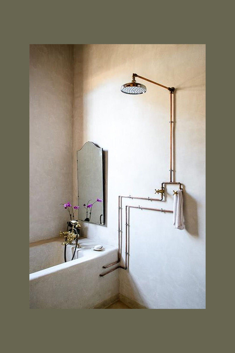 Salle de bains rustique avec des tuyaux de douche en cuivre apparents