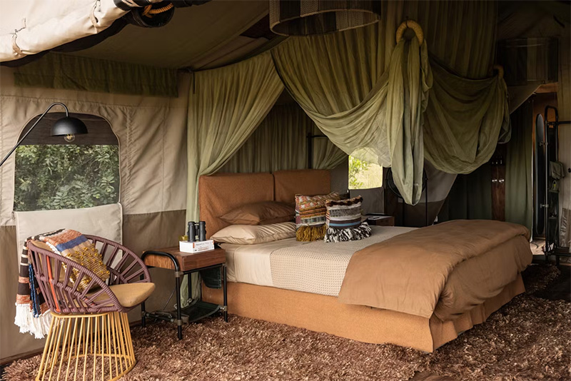 Une chambre aménagée sous une tente dans un style safari moderne