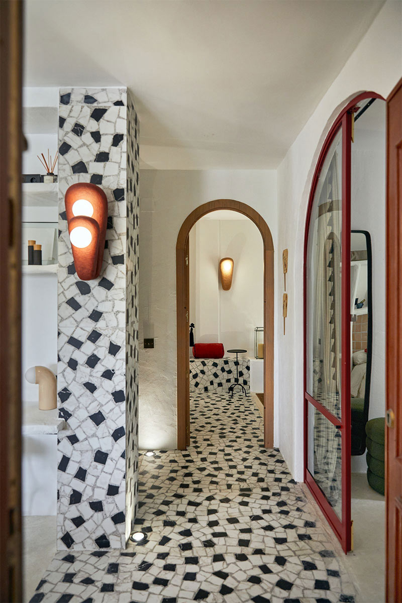 Une entrée, ornée d’une mosaïque en microquartz noir et blanc qui s’étend à la fois sur le sol et les murs