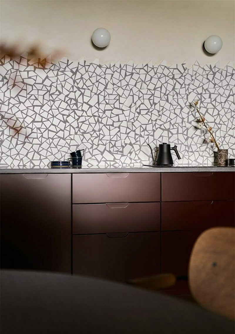 Cuisine avec des poetes de meubles en bois foncé et une crédence en mosaïque de carrelage blanc avec joints gris