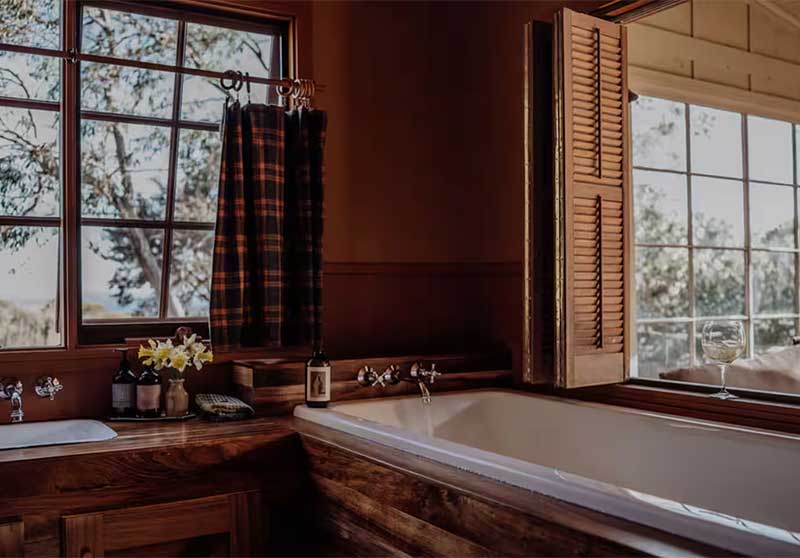 La salle de bains avec sa baignoire pouvant donner sur la pièce à vivre grâce des volets intérieurs La salle de bains avec sa baignoire pouvant donner sur la pièce à vivre grâce des volets intérieurs